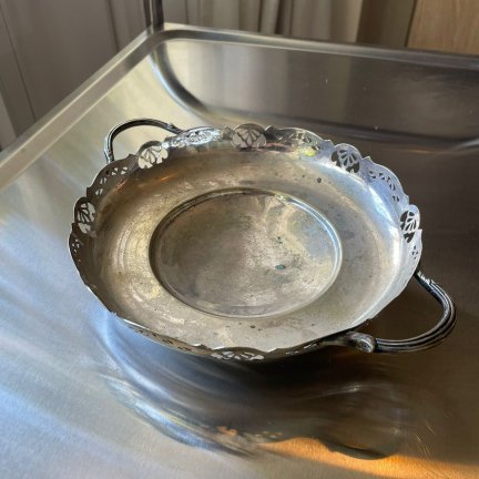 קערת מתכת עם ידיות ודוגמת חיתוך דקורטיבית